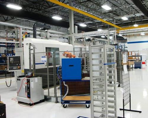 图博梅卡TMM制造工厂内部. 机械在大型工业房间与荧光灯照明.